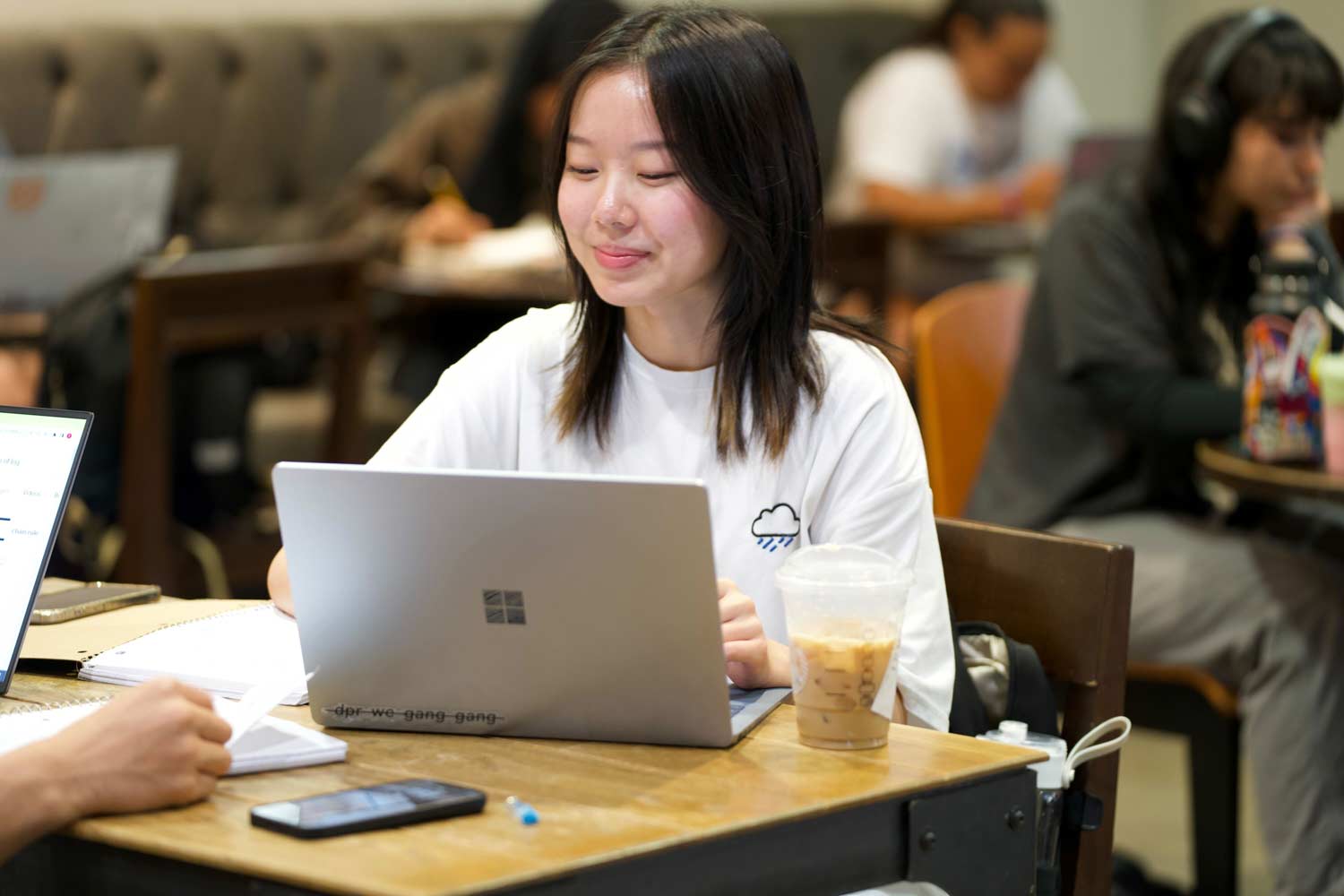 Texas A&amp;M Student works diligently on her laptop in the Evans Library Starbucks